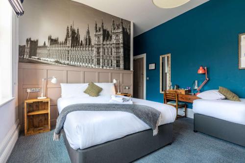 a hotel room with two beds and a desk at The Station Hotel in London