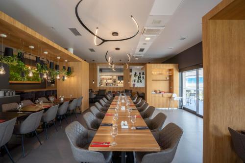 a large dining room with a long table and chairs at Ibis Hotel Plzeň in Plzeň