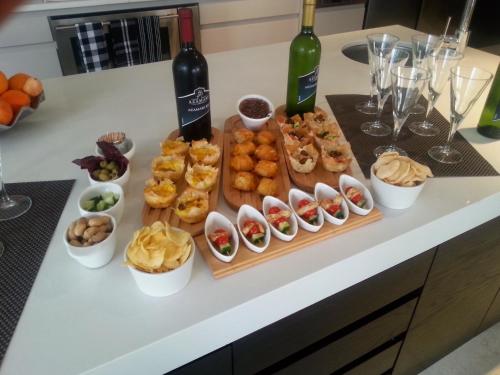 a table with two bottles of wine and bowls of food at Azamare Guest House in Cape Town