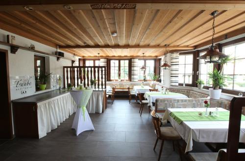 - un restaurant avec des tables et des chaises dans une salle dans l'établissement Pension zur Traube 3 Sterne, à Oberschwarzach