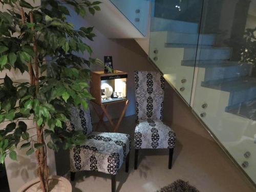 a staircase with a chair and a table and a plant at Azamare Guest House in Cape Town