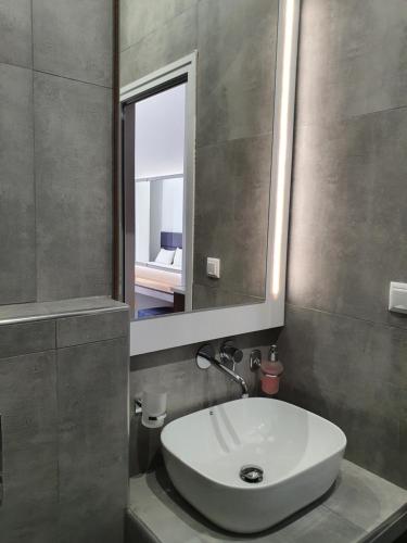 a bathroom with a white sink and a mirror at Sophia seaview suites & restaurant in Nea Vrasna