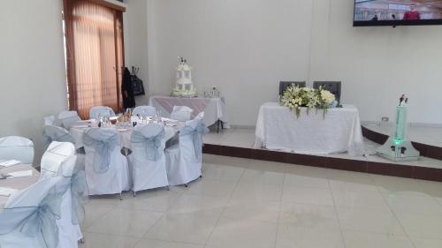 a room with white tables and chairs with white flowers at Hotel SanJo in San José Iturbide