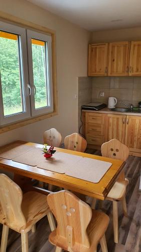 a kitchen with a wooden table and chairs at Zawoja Chaty Górskie D1 in Zawoja