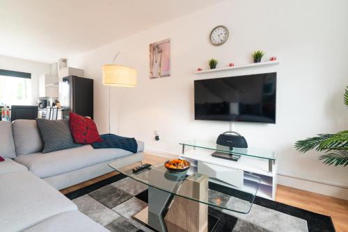 a living room with a couch and a tv at Mosh Homes in Manchester
