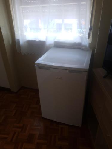 a small refrigerator in a room with a window at Truz truz4 in Porto