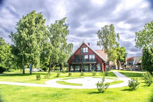 ein Haus mit Garten davor in der Unterkunft Dviviečiai apartamentai Smiltė in Preila