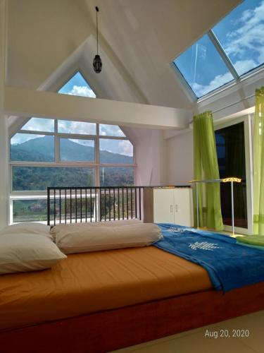 a bedroom with a bed with a large window at Rumah Kina Putih in Bandung