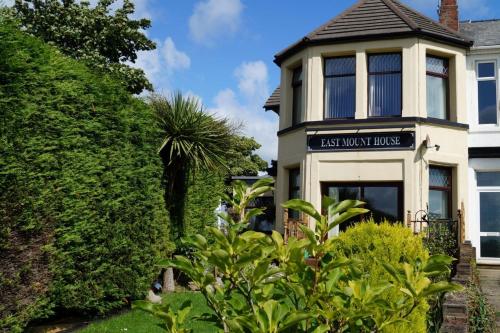 a house with a sign that reads ash monk house at East Mount House in Barrow in Furness