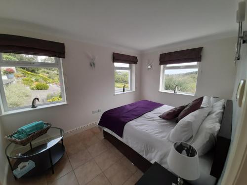 a bedroom with a large bed with two windows at At Cedar Lodge Apartment in Ramsey