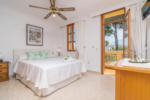 ein weißes Schlafzimmer mit einem Bett und einem Fenster in der Unterkunft Bella in Alcúdia