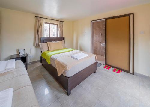 a bedroom with a bed and a couch at Joy Palace Hotel in Nairobi