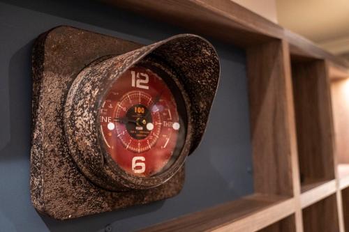 a red clock is hanging on a wall at Mercure Birmingham West Hotel in West Bromwich