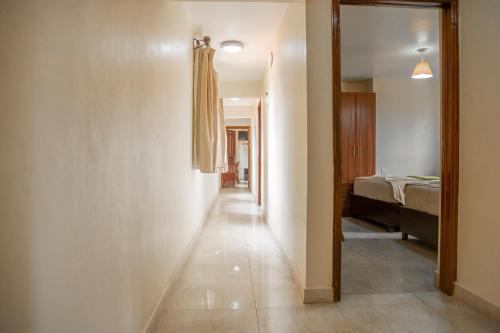 a hallway with a room with a bed and a mirror at Joy Palace Hotel in Nairobi