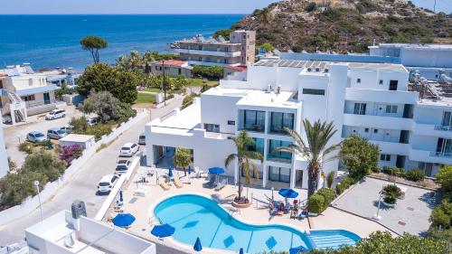 an aerial view of a building with a pool and the ocean at Moscha Hotel in Faliraki