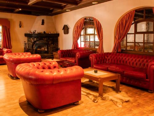a living room with red couches and a fireplace at Hotel-Restaurant Le Mont Paisible, Crans-Montana in Crans-Montana
