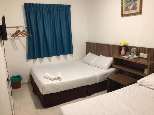 ein Schlafzimmer mit 2 Betten und einem blauen Vorhang in der Unterkunft Fragrance Hotel Johor Bahru in Skudai