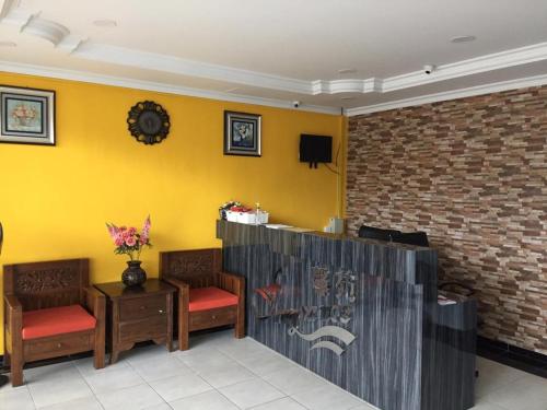 ein Wartezimmer mit Stühlen und einer gelben Wand in der Unterkunft Fragrance Hotel Johor Bahru in Skudai