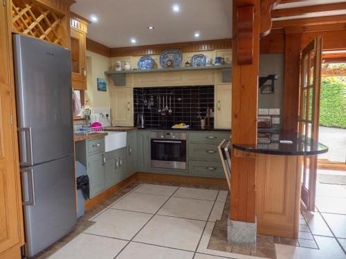 a kitchen with a refrigerator and a table in it at Crotlieve Barn in Rostrevor