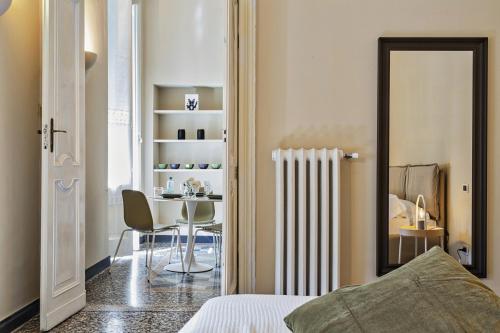 Un dormitorio con una cama, una mesa y una silla. en Via Roma Luxury Apartment by Wonderful Italy, en Génova