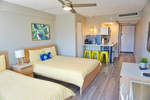 a hotel room with two beds and a kitchen at Daytona Inn Studios in Daytona Beach