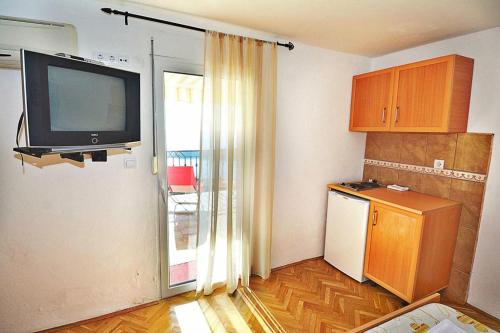 cocina con nevera y TV en la pared en MARINOVIC APARTMENTS, en Budva
