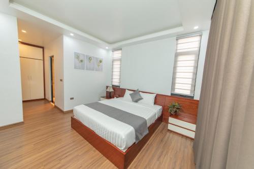 sypialnia z dużym białym łóżkiem i oknami w obiekcie Villa FLC BT 10 -04 w Ha Long