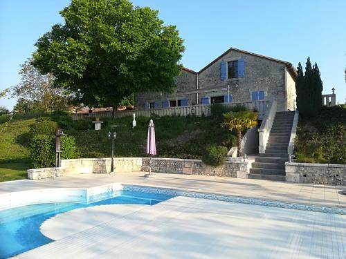 a swimming pool in front of a house at Le Maine Menot in Salles-Lavalette