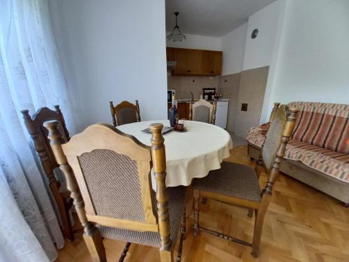 comedor con mesa, sillas y sofá en Smestaj Stanisavljevic, en Soko Banja