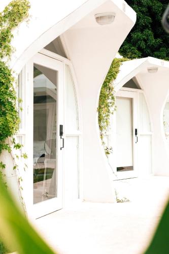 a white house with two large windows at Igloo Beach Lodge in Manuel Antonio