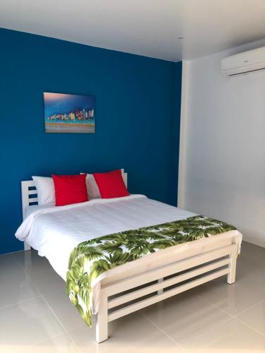 a blue bedroom with a bed with red pillows at SiRi Resort in Maha Sarakham