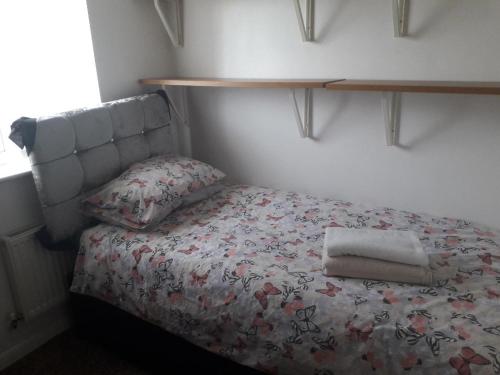 a bedroom with a bed with a shelf on the wall at Greenock Home Stay in Wolverhampton