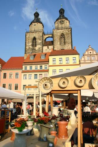 a market in front of a building with two towers at martas Hotel Lutherstadt Wittenberg in Lutherstadt Wittenberg