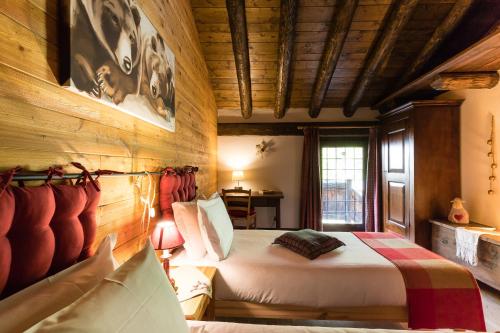 1 dormitorio con 1 cama y pared de madera en Revivre Village Adults only en Champorcher