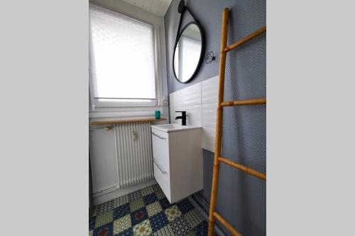 une salle de bain avec un lavabo et une fenêtre dans l'établissement Le Smile, à Calais