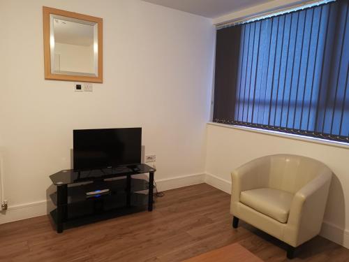 a living room with a chair and a television at Miller Suite in Kent