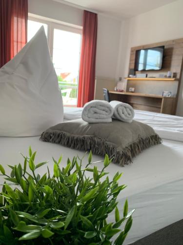 a bedroom with a bed with two towels and a plant at Residenz Hotel Giessen in Gießen