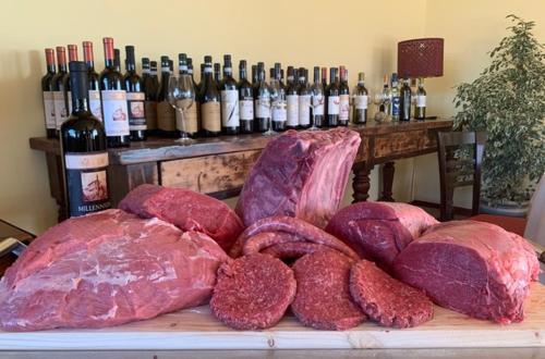 a pile of meat on a table with bottles of wine at Hotel Erbaluce in Caluso