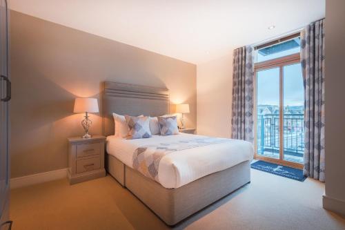 a bedroom with a bed and a large window at Highland Apartments by Mansley in Inverness