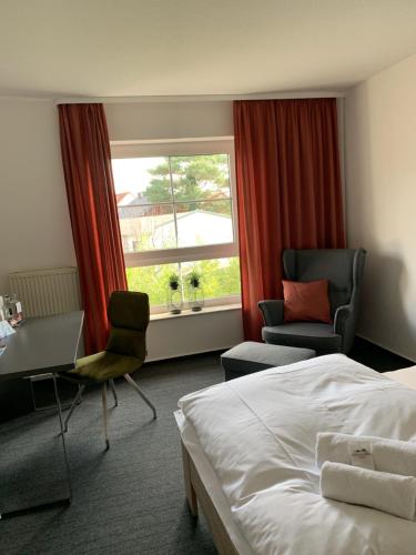 um quarto de hotel com uma cama, uma secretária e uma janela em Residenz Hotel Giessen em Gießen