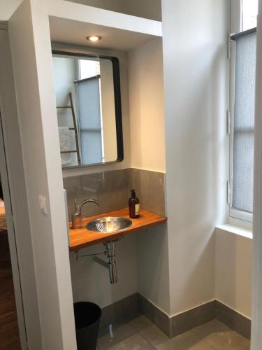 a bathroom with a sink, toilet and window at Le Doyenné - Hôtel de charme - Hypercentre in Le Mans