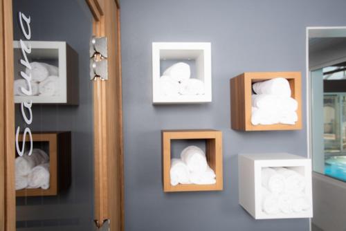 a wall with threeangularangular boxes of towels at Hotel Les Dunes in La Tranche-sur-Mer