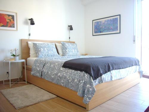 a bedroom with a bed with blue and white sheets at Castle, Terrace and Relax in Tomar