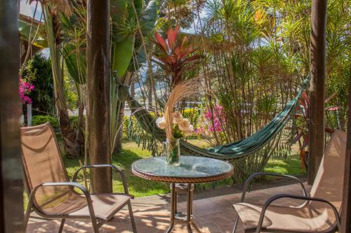 a table and chairs on a patio with a hammock at Pousada Sonho Meu in Itanhandu