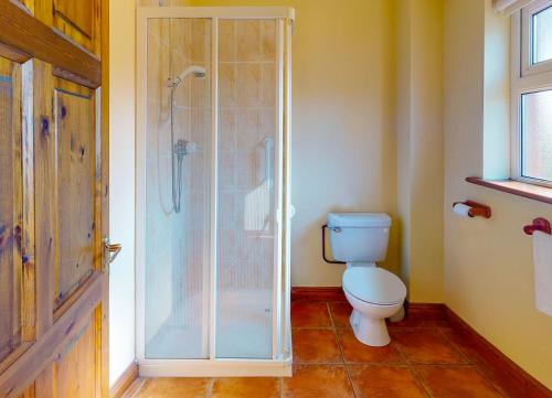e bagno con servizi igienici e doccia in vetro. di Seacliff Holiday Homes a Dunmore East