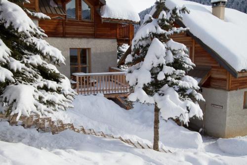eine Blockhütte im Schnee mit Bäumen in der Unterkunft Le Meï Hameau des Chazals Nevache Hautes Alpes in Névache