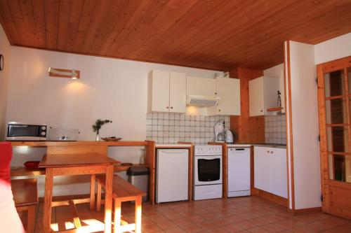 eine Küche mit weißen Geräten und einer Holzdecke in der Unterkunft Le Meï Hameau des Chazals Nevache Hautes Alpes in Névache