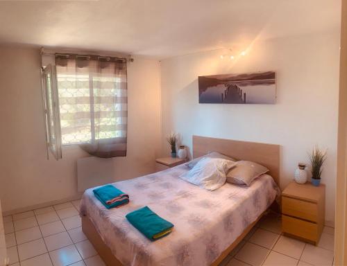 ein Schlafzimmer mit einem Bett mit zwei Handtüchern darauf in der Unterkunft Sun7 view Montpellier, Piscine, Parking GRATUIT in Grabels