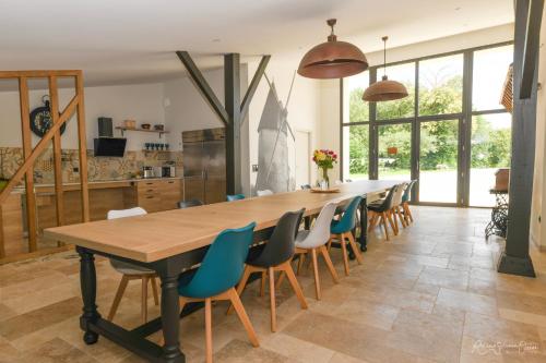 une grande salle à manger avec une longue table et des chaises dans l'établissement Les Chambres d'Aurore, à Chambretaud