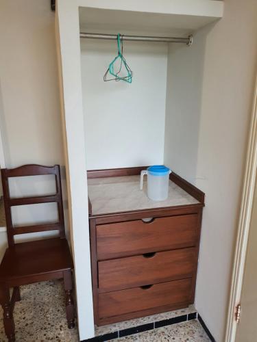 a closet with a wooden dresser and a chair at Hotel Atlantico a 150 mts de Playa Martí in Veracruz